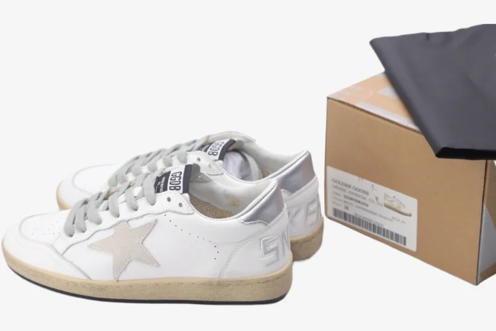 White and silver Golden Goose Ball Star distressed leather sneakers with shoebox and dust bag, side view. - SKU GWF00117.F002570.10925