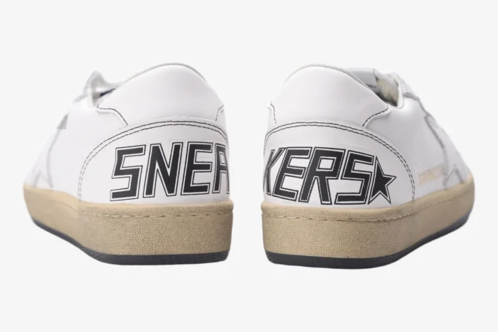 Rear view of Golden Goose BallStar white leather sneakers with black 'SNEAKERS' text on the heels. - SKU GMF00117.F000632.10273