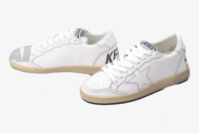 Pair of Golden Goose BallStar white and black distressed leather sneakers shown from a side angle. - SKU GMF00117.F000632.10273