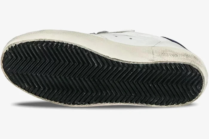 Bottom view of Golden Goose Super-Star sneaker showing black herringbone outsole and distressed white midsole. - SKU GWF00101.F000321.10271