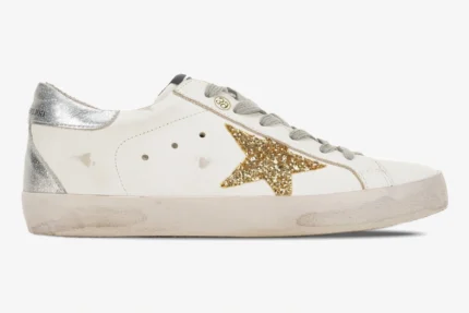 Golden Goose Super-Star sneaker in white with a gold glitter star and silver heel tab, side view. - SKU GWF00101.F000312.10272