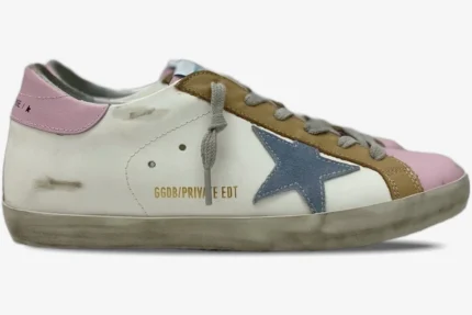 Side profile of Golden Goose Super-Star sneakers in white with pink accents, a blue star, and brown details.