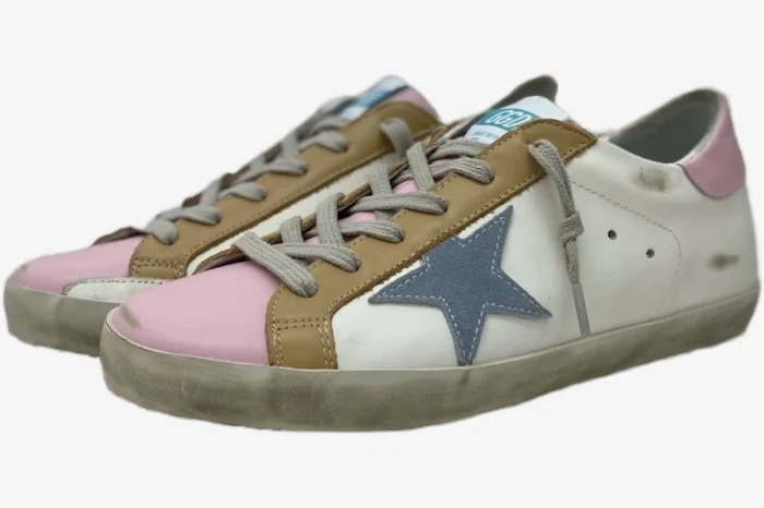 Golden Goose Super-Star sneakers with pink toe, brown trim, and blue star, three-quarter side view.