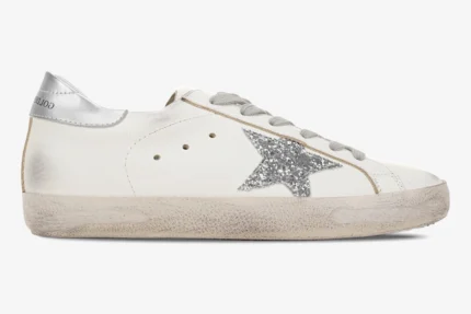 White Golden Goose Super-Star sneaker with a silver glitter star and distressed sole, side view. - SKU GWF00101.F000312.80185