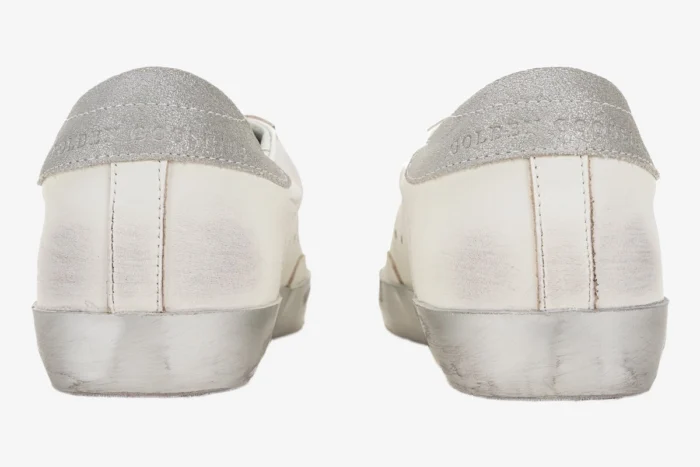 Rear view of Golden Goose White and Silver Super-Star Sneakers with distressed silver soles and glitter heel tabs. - SKU GMF00101.F000312.10273