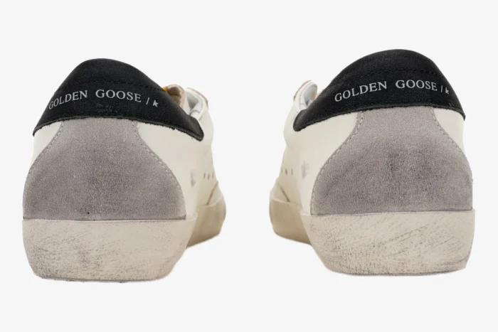 Rear view of Golden Goose Super-Star sneakers in white with grey suede and black logo heel tabs. - SKU GMF00101.F000312.10273