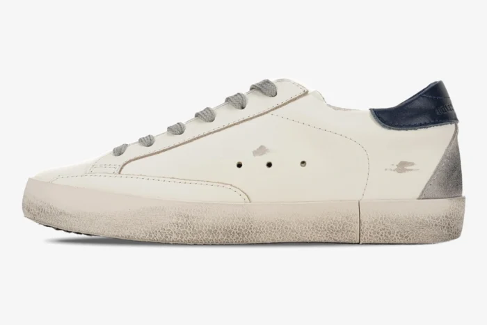 Side profile of a white Golden Goose Super-Star leather sneaker with a blue heel tab and distressed finish. - SKU GMF00101.F000312.10273