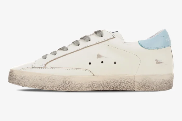 Side view of a white Golden Goose Super-star sneaker with a light blue heel tab and signature distressed finish. - SKU GWF00101.F000312.10273