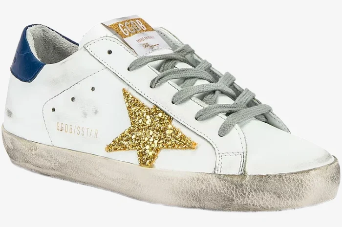 Golden Goose Super-Star sneaker in white with a gold glitter star and navy heel, side view. - SKU GWF00101.F000321.10271