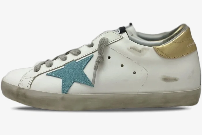 Side view of Golden Goose Super-Star white distressed leather sneakers with a green star and gold heel. - SKU GWF00101.F000312.10273