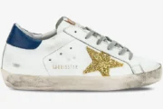 Golden Goose Super-Star white leather sneaker with gold glitter star and navy heel tab, side profile view. - SKU GWF00101.F000321.10271