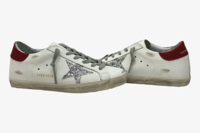 Side profile of white Golden Goose Super-Star sneakers with silver glitter stars and red heel tabs. - SKU GWF00101.F000312.10272