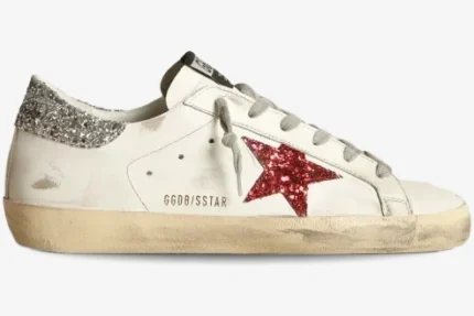 Side view of a Golden Goose Super-Star sneaker in white leather featuring a red glitter star and silver glitter heel. - SKU GWF00101.F000312.10273