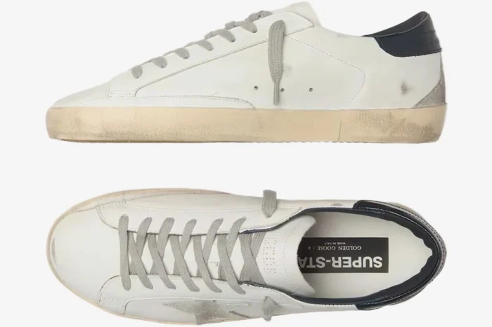 Side profile of Golden Goose Super-Star white leather sneaker with a blue heel tab and distressed sole. - SKU GMF00101.F000312.10273