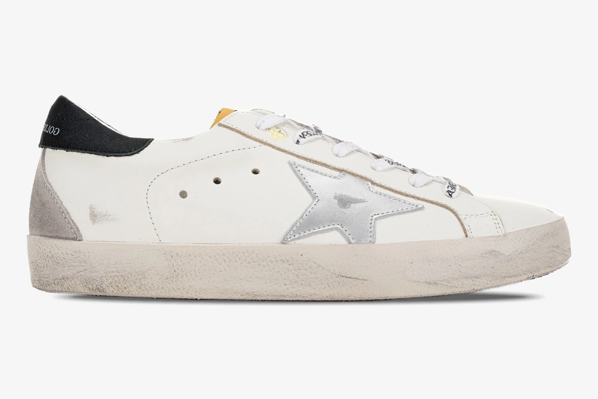 golden-goose-super-star-white-silver-black-side-gmf00101-f000312-10273-646-269 Side profile of Golden Goose Super-Star white leather sneakers with metallic silver star and black heel tab. - SKU GMF00101.F000312.10273