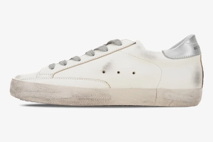 Side profile of a white Golden Goose Super-Star sneaker with distressed details and silver heel tab. - SKU GWF00101.F000312.80185