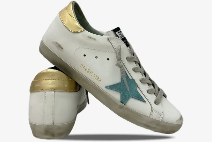 Golden Goose Super-Star white leather sneakers with teal star and gold heel tab, side and back view. - SKU GWF00101.F000312.10273