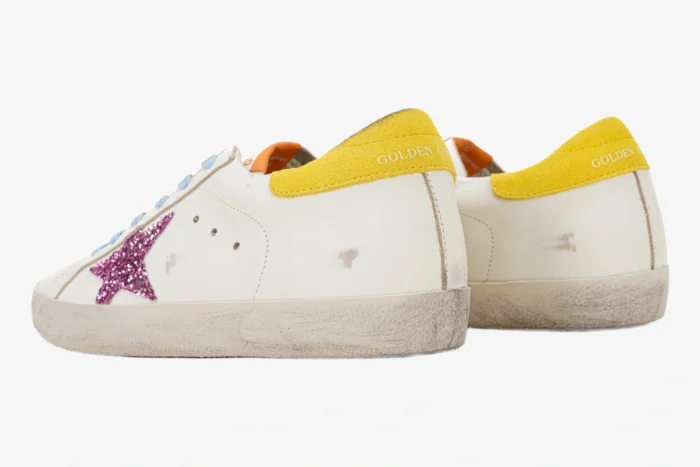 Golden Goose Super-star white sneakers with pink glitter star and yellow heel tab, rear side view. - SKU GWF00101.F002559.10928
