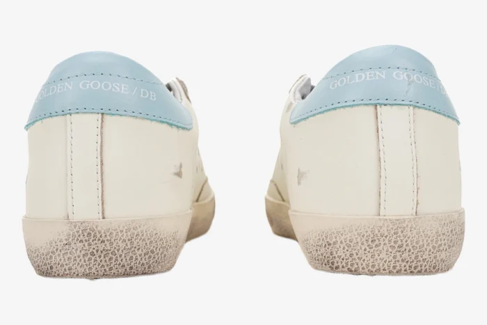 Rear view of Golden Goose Super-star white leather sneakers with light blue heel tabs. - SKU GWF00101.F000312.10273