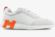 Hermes Bouncing Sneaker in white and orange mesh, side profile view on a white background. - SKU H202934ZH
