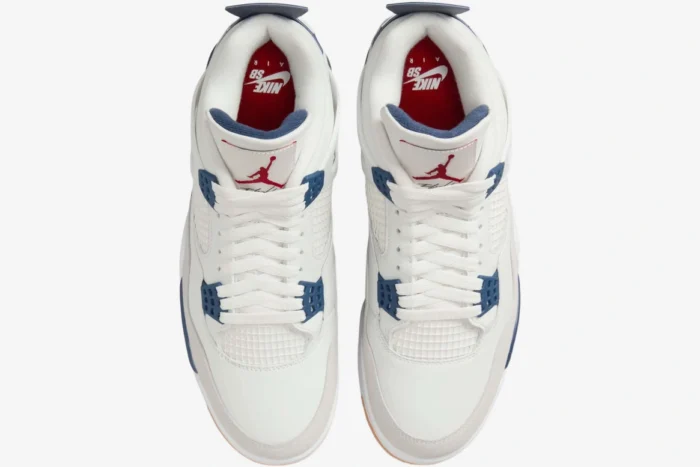 Top-down view of Nike SB x Air Jordan 4 Navy sneakers in white and blue with red insoles. - SKU DR5415-100