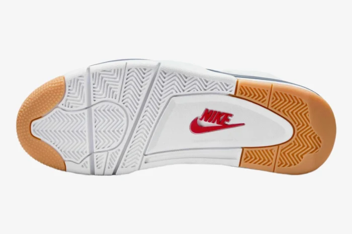 Bottom view of Nike SB Jordan 4 Navy outsole featuring white and gum rubber with red Nike logo. - SKU DR5415-100