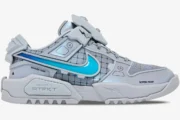 Side profile of grey RTFKT x Nike Dunk Genesis OG sneakers with bright blue swoosh and futuristic panels.